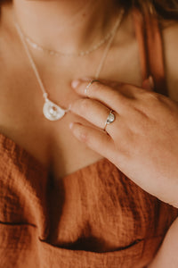Delicate silver arch ring with sun rays beaming from quartz.
