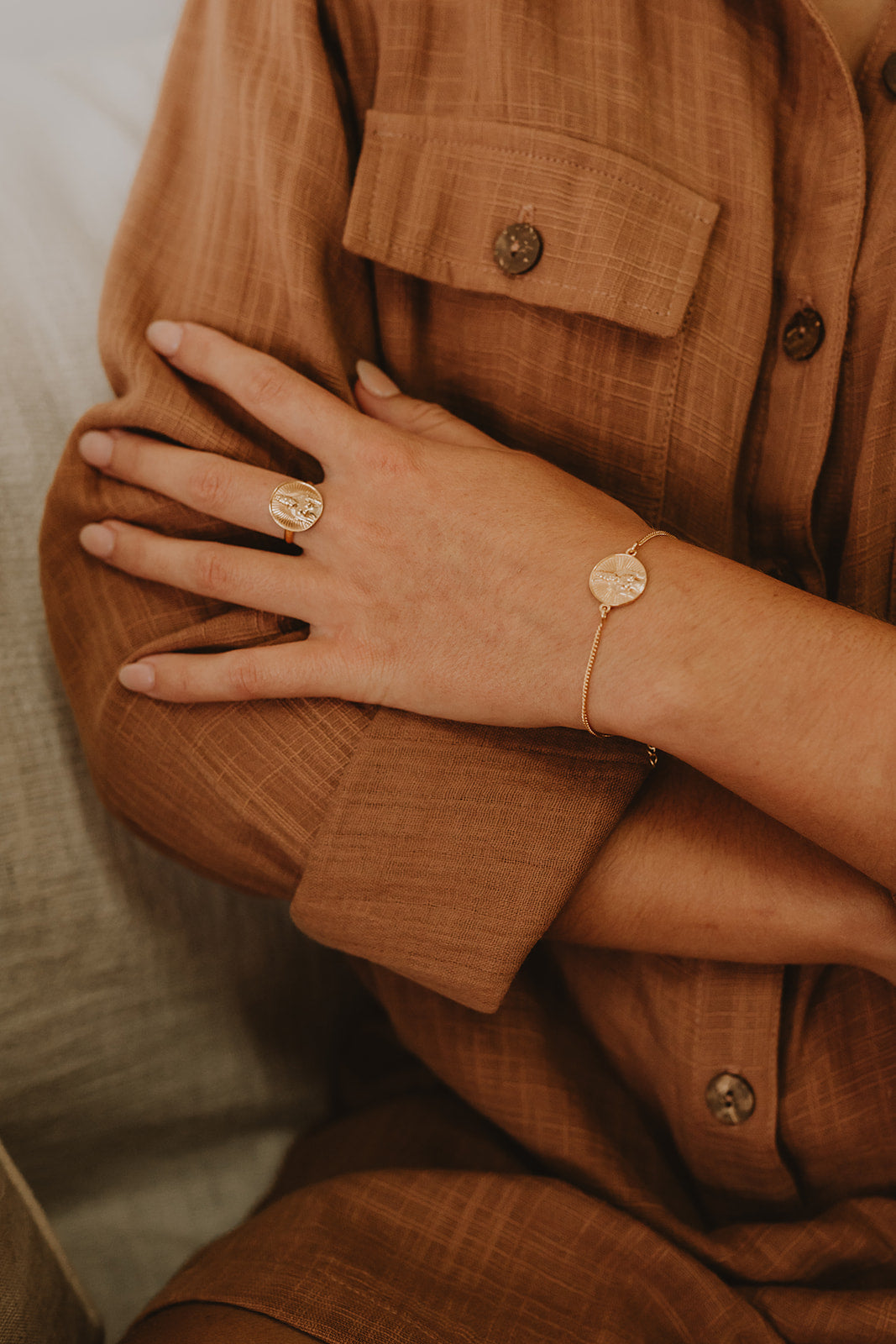 Delicate gold ring with Rati stamped into circle on model.