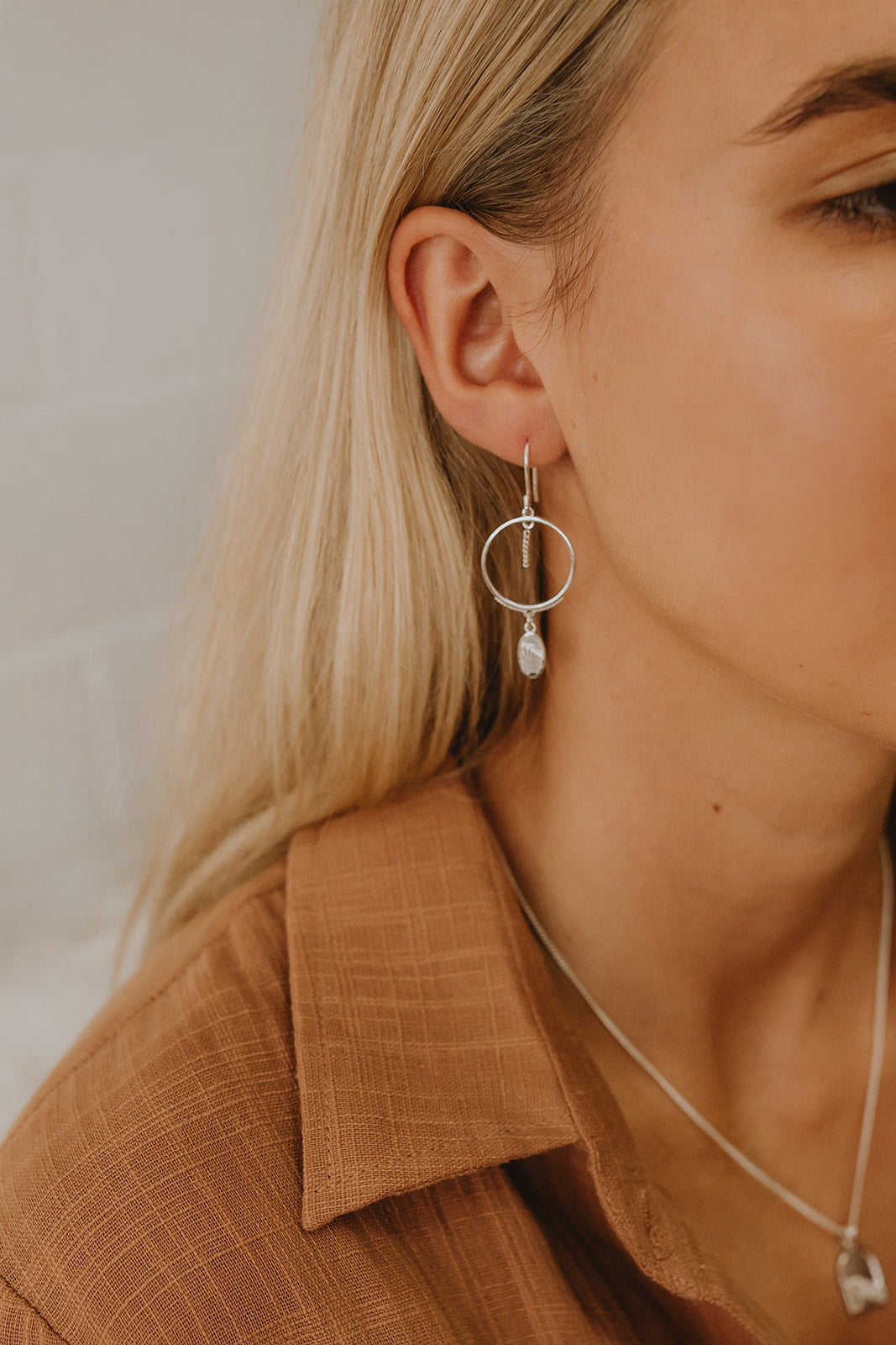 Delicate Sammy silver dangle hoop earrings with embellishments on model.