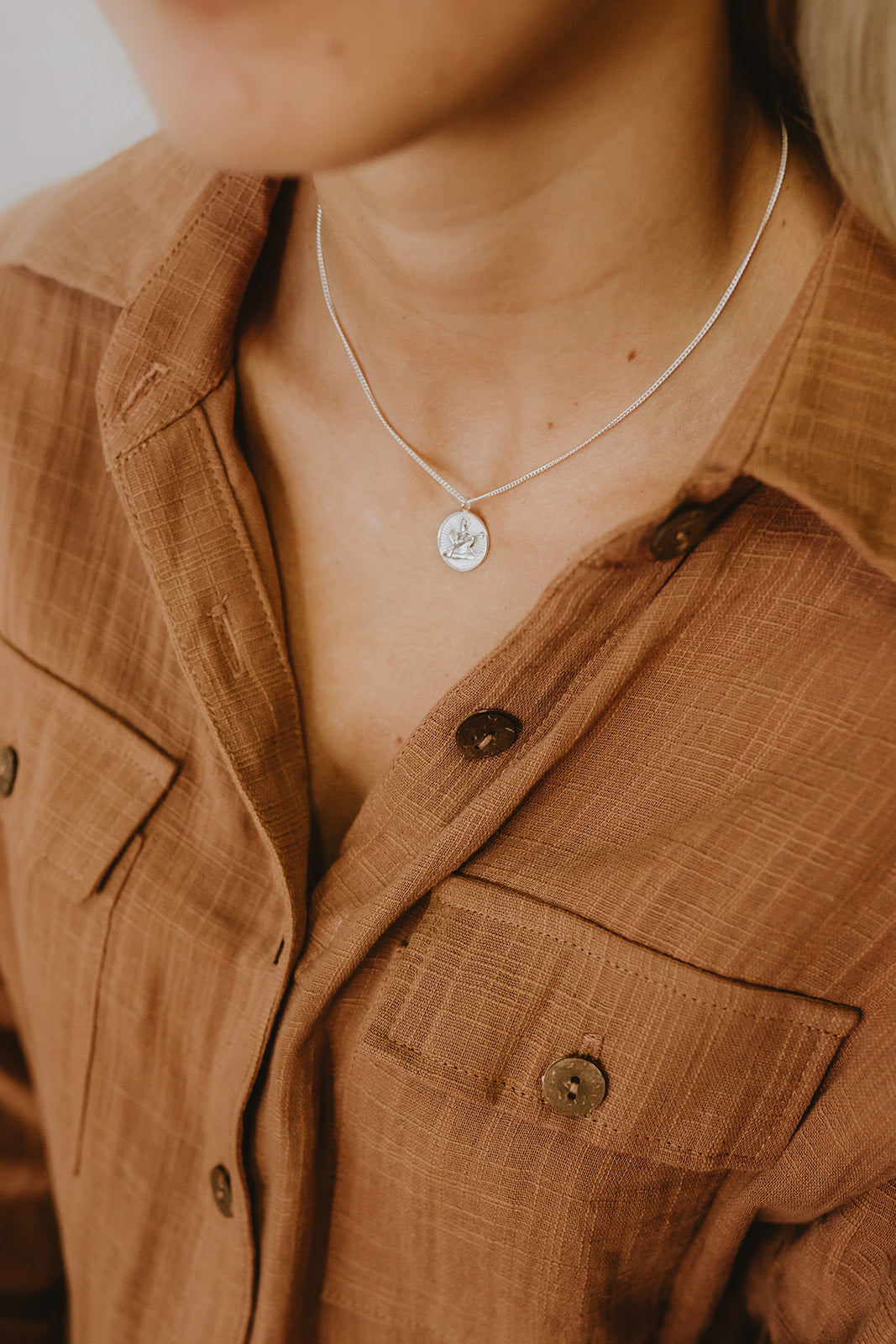 Delicate silver necklace with Saraswati stamped into circle pendant on necklace